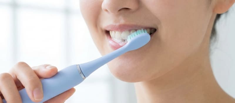 Utilisation d'une brosse à dents sonique douce sur des gencives sensibles.